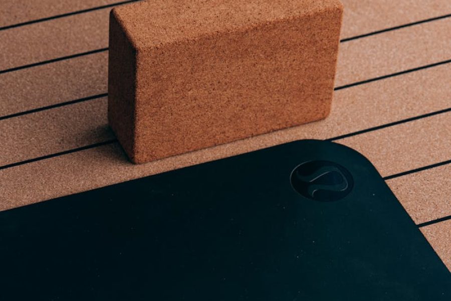 Close-up of a cork yoga block and striped yoga mat, essential for fitness routines.